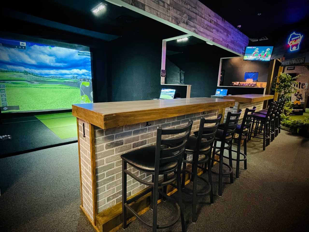 Full Swing simulator bays with wood counters and seating at Stix Germantown